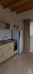 a kitchen with a sink and a stove and a refrigerator at Balcon al dique in Las Chacras