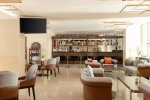 a lobby with a bar with chairs and tables at Ramada Plaza by Wyndham Gence in Ganja