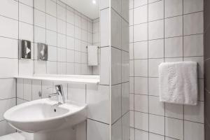 a white bathroom with a sink and a mirror at Ramada London Stansted Airport in Stansted Mountfitchet +32 photos