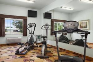 a gym with two exercise bikes and a mirror at Days Inn & Suites by Wyndham Columbus NE in Columbus