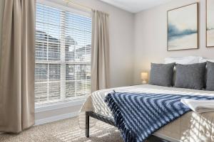 a bedroom with a bed and a large window at Spacious 2BR House, Steps from A&M - King - Patio in College Station