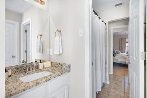 a white bathroom with a sink and a mirror at Spacious 2BR House, Steps from A&M - King - Patio in College Station +10 photos