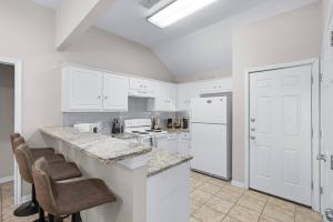 a kitchen with white cabinets and a white refrigerator at Spacious 2BR House, Steps from A&M - King - Patio in College Station