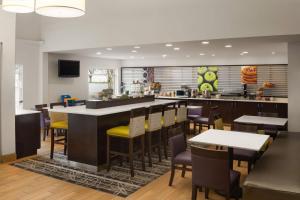 a restaurant with a bar with yellow chairs and tables at La Quinta by Wyndham Spokane Valley in Spokane Valley