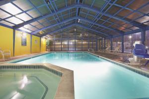 a large swimming pool in a building at La Quinta Inn by Wyndham Salt Lake City Midvale in Midvale