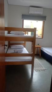 a bedroom with two bunk beds and a window at Duplex 2 Suites Pool Barbecue Air in Santa Cruz Cabrália