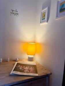 Eine Lampe auf einem Tisch mit einer Zeitschrift. in der Unterkunft CloudZen in Kent