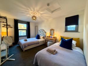 ein Schlafzimmer mit zwei Betten und einem Tisch mit Schreibtisch in der Unterkunft CloudZen in Kent