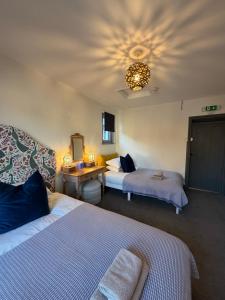 ein Schlafzimmer mit zwei Betten und einem Schreibtisch mit Spiegel in der Unterkunft CloudZen in Kent