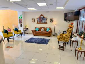 a living room with couches and chairs and a flat screen tv at Casa de la iaia Hotel in Orizaba