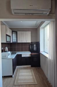 a kitchen with black and white appliances and a window at Apartament Balti in Bălţi