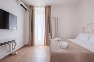 a hotel room with a bed with towels on it at Rooms 2Binari in Bologna