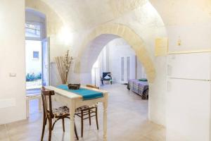 a kitchen with a table and a room with a bed at Dimora nei Sassi in Matera