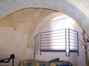 een kamer met een bed en een boog in de muur bij Dimora nei Sassi in Matera