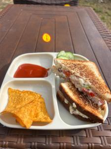 a white tray with a sandwich and chips and ketchup at MADLERS by Oakland House in Manāli