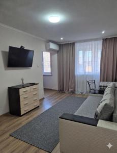 a living room with a couch and a flat screen tv at Apartament Balti in Bălţi