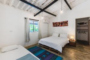 a bedroom with two beds and a window at Rio Elemento Minca in Santa Marta
