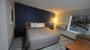 a bedroom with a bed and a blue wall at Roosevelt Inn at Roosevelt Blvd, Philadelphia, PA in Philadelphia +9 photos