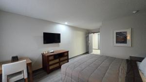 a bedroom with a bed and a tv on the wall at Roosevelt Inn at Roosevelt Blvd, Philadelphia, PA in Philadelphia