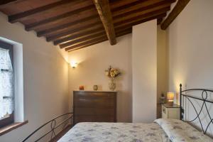 a bedroom with a bed and a wooden ceiling at Podere il Granaio - Crete Senesi - Tuscany in Siena