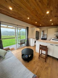a living room with a bed and a kitchen at The Farm in Whangaruru