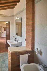 a bathroom with two sinks and a mirror at Podere il Granaio - Crete Senesi - Tuscany in Siena +52 photos