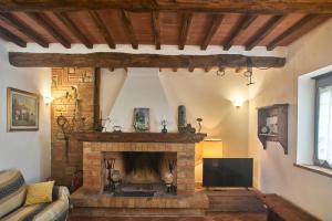 a living room with a fireplace and a tv at Podere il Granaio - Crete Senesi - Tuscany in Siena