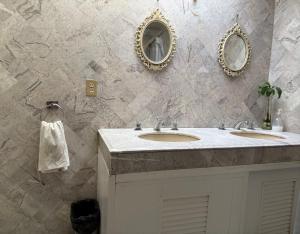 a bathroom with two sinks and two mirrors on the wall at Margaritas Eco Haus in Querétaro +74 photos