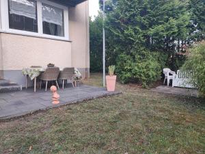 a patio with a table and chairs in a yard at Apartment For You in Hameln