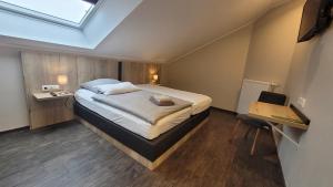 a bedroom with a bed and a desk and a window at Hof Hahnenberg in Wagenfeld