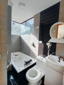 a bathroom with a toilet and a sink and a tub at Hotel California Calca in Calca +61 photos