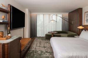 a hotel room with a bed and a couch at The Greenleigh, River Oaks, Autograph Collection in Houston