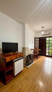 a living room with a television and a fireplace at Ninho dos Passaros Penedo RJ in Penedo