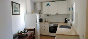 a kitchen with white cabinets and a white refrigerator at Casa dos Avós Palma - Alcoutim in Alcoutim