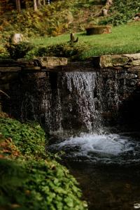 a small waterfall on a stone bridge over a creek at Domek Orlické hory in Deštné v Orlických horách +5 photos