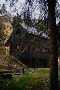 an old barn with a tree in front of it at Domek Orlické hory in Deštné v Orlických horách