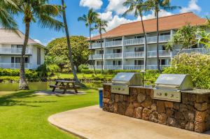a resort with a picnic table and palm trees at Kiahuna Plantation Resort Kauai by OUTRIGGER in Koloa