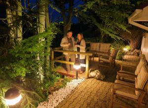 Ein Mann und eine Frau stehen nachts neben einem Zaun. in der Unterkunft FOREST RETREAT Luxury Villas in Buşteni