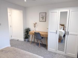 a room with a desk and a bedroom with a bed at Spacious En-suite Private Double Bedroom in Oxford