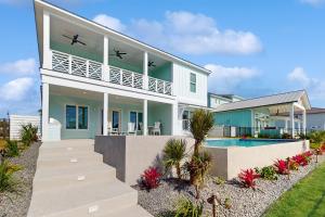 a house with a swimming pool in front of it at Tortuga Palms in Rockport