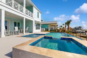 a swimming pool in front of a house at Tortuga Palms in Rockport