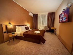 ein Hotelzimmer mit einem großen Bett und einem Schreibtisch in der Unterkunft Hotel NIRÁ in Sofia