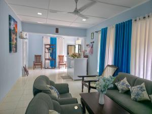 a living room with blue curtains and couches at The Duchess Hotel in Matara