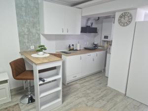 a kitchen with white cabinets and a table in it at City Studio in Târgu Secuiesc
