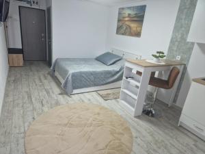 a bedroom with a bed and a desk and a table at City Studio in Târgu Secuiesc