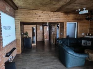 a living room with a black couch and a brick wall at Vinný sklípek u Dědy in Hrušky