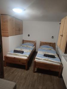two twin beds in a room with wooden floors at Vinný sklípek u Dědy in Hrušky
