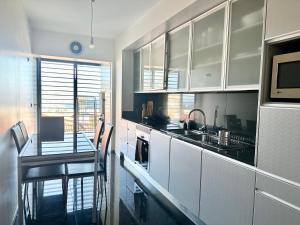 a kitchen with white cabinets and a table and a counter at Precious Relaxation Rooms in Funchal in Funchal