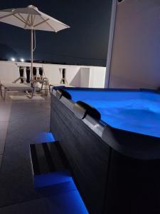 a swimming pool in a room with an umbrella at Pension St.George Rooms & Studios in Perivolos