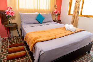 a bedroom with two beds with towels and flowers at Hotel Casa Real Villeta in Villeta